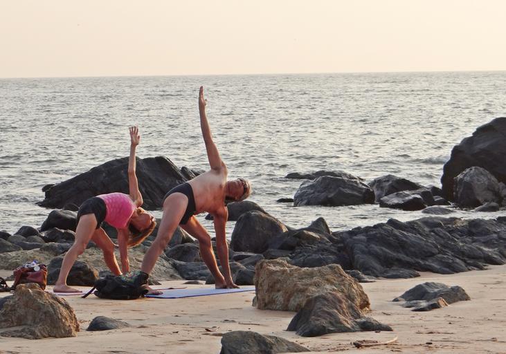 Žena a muž cvičia na pláži na športových podložkách.jpg